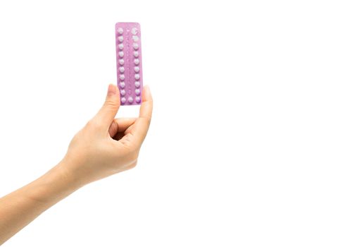 Asian young woman holding pack of contraceptive pills with one hand isolated on white background with copy space and clipping path. Choosing family planning with birth control pill concept