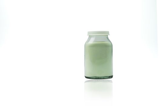 Green lemon flavored effervescent powders in transparent glass bottle with blank label and copy space isolated on white background. Pharmaceutical packaging industry.