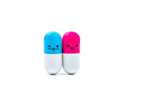 Cute blue and pink couple capsule pills isolated on white background with copy space for text. Global healthcare concept. Taking care of couple life. Pharmaceutical industry. Pharmacy sign and symbol. Pharmacy background. Health budgets and policy.