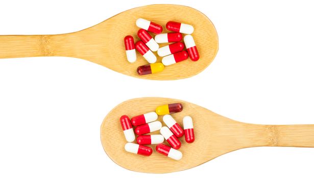 Colorful of antibiotics capsule pills in wooden spoon isolated on white background with copy space. Drug resistance concept. Antibiotics drug use with reasonable and global healthcare concept. Pharmaceutical industry. Pharmacy background.