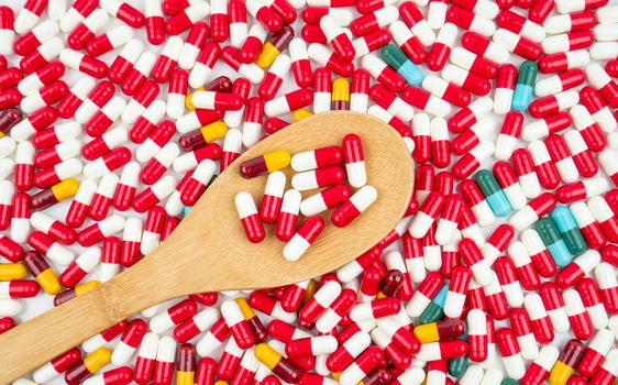Colorful of antibiotic capsules pills and wood spoon on white background. Drug resistance concept. Antibiotics drug use with reasonable and global healthcare concept.