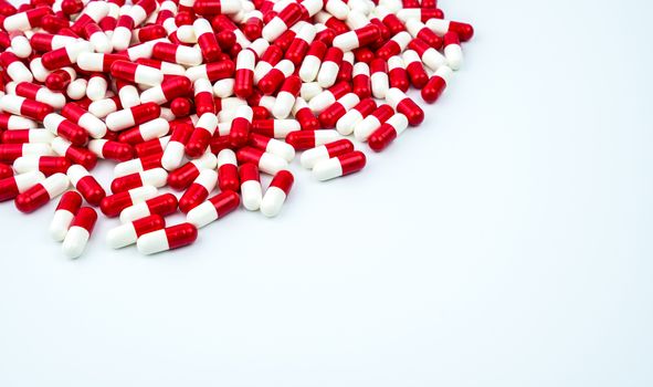 Red, white antibiotic capsules pills on white background with copy space. Drug resistance, antibiotic drug use with reasonable. Antibiotics drug overuse. Pharmaceutical industry. Pharmacy products.