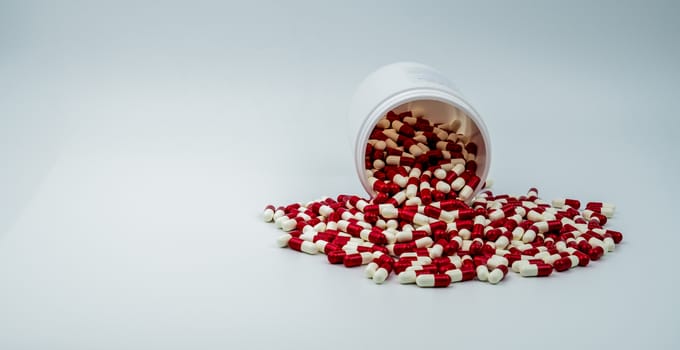 Colorful of antibiotic capsules pills with plastic bottle isolated on white background. Drug resistance, antibiotic drug use with reasonable. Antibiotics drug overuse. Pharmaceutical industry. Pharmacy background.