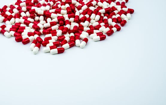 Red, white antibiotic capsules pills on white background with copy space. Drug resistance, antibiotic drug use with reasonable. Antibiotics drug overuse. Pharmaceutical industry. Pharmacy products.