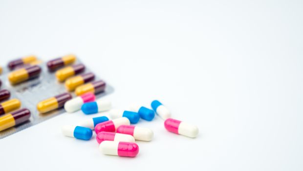 Colorful of antibiotic capsules pills on blurred background with copy space. Drug resistance, antibiotic drug use with reasonable, health policy and health insurance concept. Pharmaceutical industry. Pharmacy background.