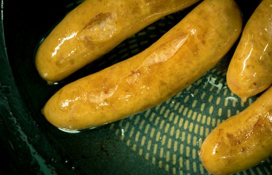 Fried pork sausage in a pan. Unhealthy food. Food can cause rectal and colon cancer.