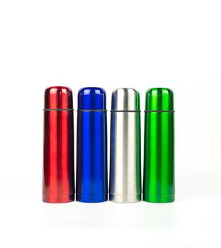 Red, blue, silver and green thermos bottles isolated on white background with copy space