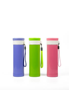 Purple, green and pink thermos bottles isolated on white background with copy space