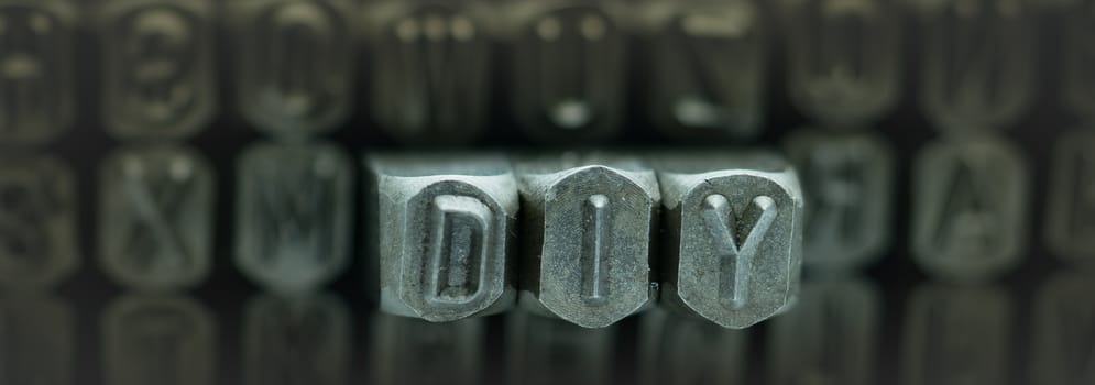 DIY spelled from metal stamp alphabet punch, DIY words stand for Do It Yourself concept