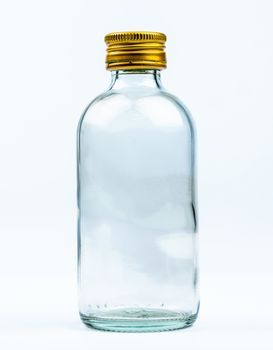Empty transparent round glass bottle with closed aluminum yellow cap isolated on white background with blank label and copy space. Use for beverage or medicine product design template.