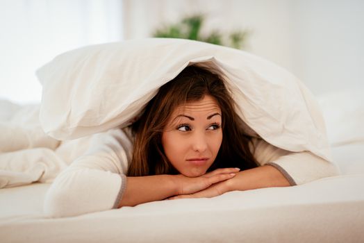 Young beautiful woman lying in the bed in morning and she is doesn't want to wake up. 