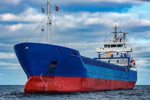 Blue cargo ship moored in still Baltic sea water