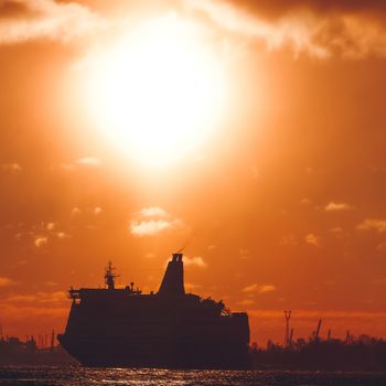 Hot orange winter sunrise against the cargo port