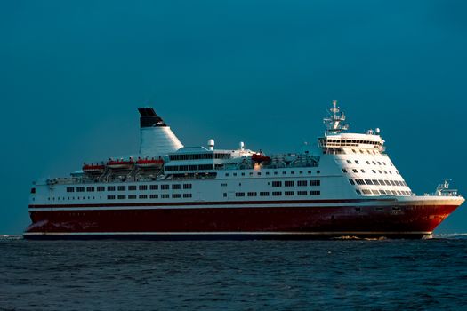Red cruise liner. Passenger ship sailing from the sea in the morning