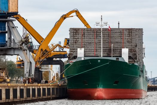 Green cargo ship loading in the port of Riga, Europe
