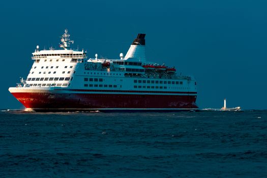 Red cruise liner. Passenger ship sailing from the sea in the morning