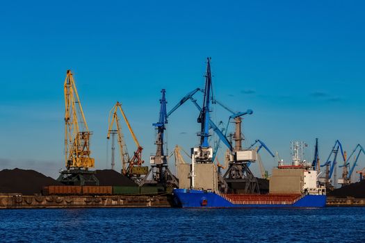 Blue cargo ship loading in the port of Riga, Europe