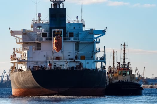 Black cargo ship entering the port of Riga, Europe