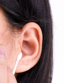 Woman with black hairs is cleaning her ears with white cotton bud. Personal hygiene concept.