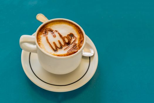 Cappuccino on a cup with foam and above the foam the inscription Cuba on a background