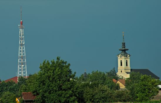 Radio tower and church tower spiking above trees