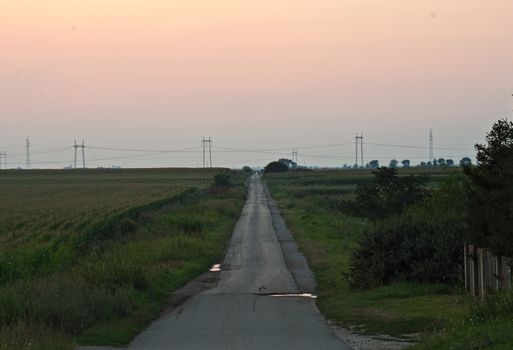 Sunset over empty countryside road, summer landscape