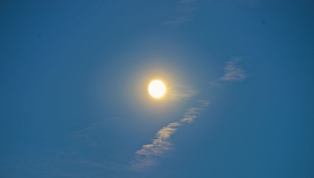 Full moon during sunset on blue sky