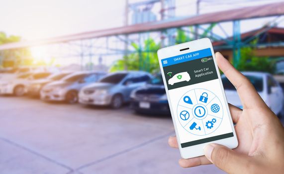 Auto parking and Smart pick me up application, Auto drive function and internet of things in smart car concept. Hand holding smart phone and application dashboard with blur car parking background.