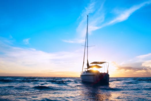 The boat on the sea. The silhouette boat and sunlight be hide. The small boat is running on the blue sea.