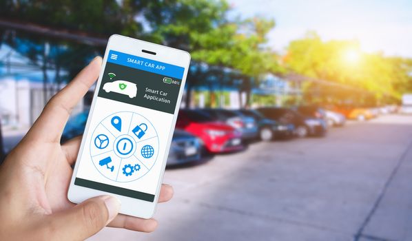 Auto parking and Smart pick me up application, Auto drive function and internet of things in smart car concept. Hand holding smart phone and application dashboard with blur car parking background.