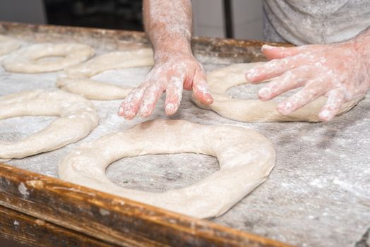 Baker hands kneading bread dough 