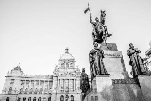 The bronze equestrian statue of St Wenceslas at the Wenceslas Square with historical Neorenaissance building of National Museum in Prague, Czech Republic. Black and white image.