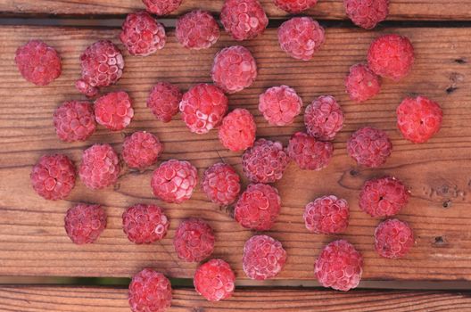 Raspberry is spread out on a wooden background