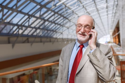 Senior businessman walking and having a conversation at phone