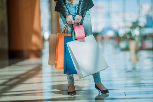 Sale and people - smiling woman with colorful shopping bags over supermarket background