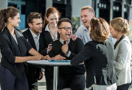 Group of happy business people congratulating their successful coworker