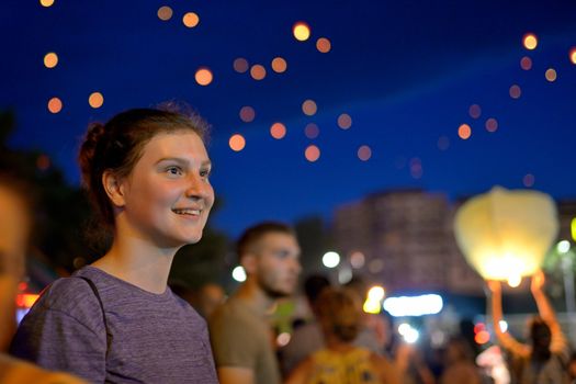 Teen girl  in summer night watching paper lantern