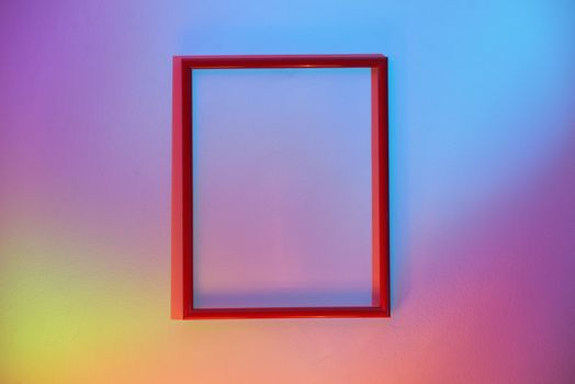 Empty Red Frame Hanging On A Colorful Wall