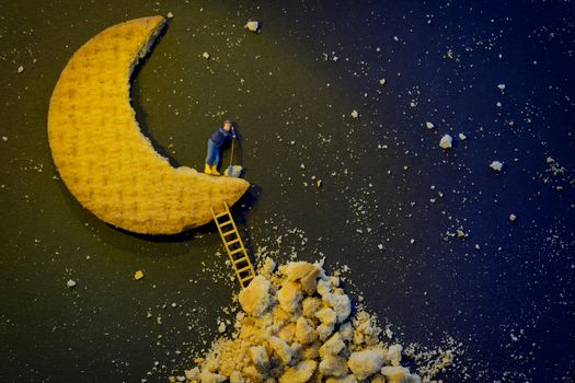 Miniature worker repairing the half moon in night night shift