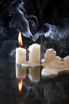 Set of extinguished candles with fire and smoke on nice dark background