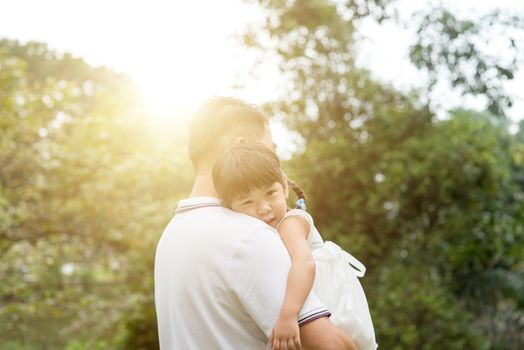 Asian family outdoors portrait. Father and daughter at green park. 