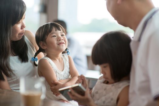 Candid shoot of people in cafeteria. Little girl with various face expression. Asian family outdoor lifestyle with natural light.