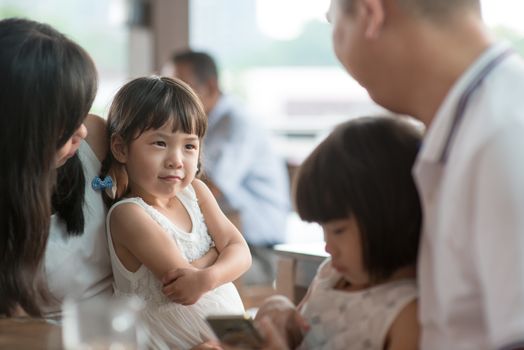 Candid shoot of people in cafeteria. Little girl with various face expression. Asian family outdoor lifestyle with natural light.