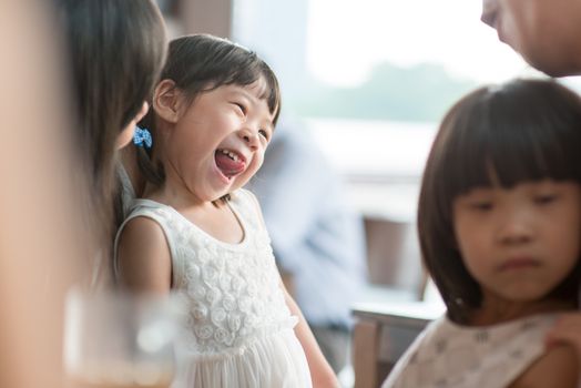 Candid shoot of people in cafeteria. Little girl with various face expression. Asian family outdoor lifestyle with natural light.