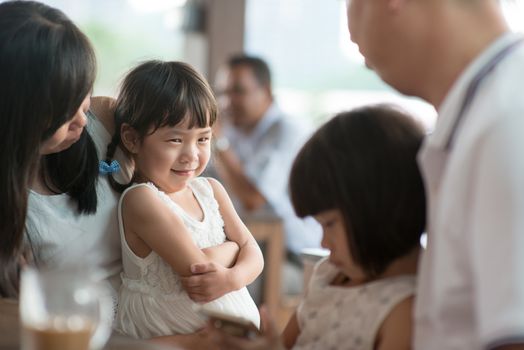 Candid shoot of people in cafeteria. Little girl with various face expression. Asian family outdoor lifestyle with natural light.