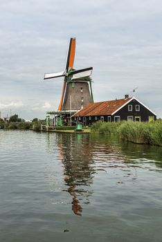 Authentic Zaandam mills on the water channel in Zaanstad village. Zaanse Schans Windmills and famous Netherlands canals, Europe.