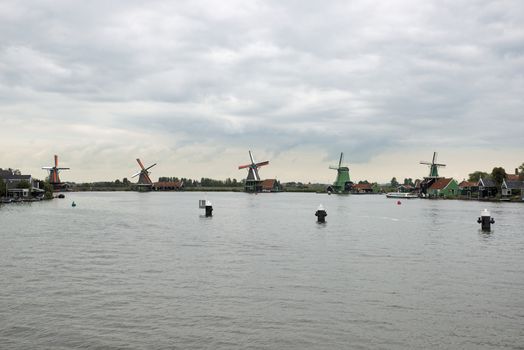 Authentic Zaandam mills on the water channel in Zaanstad village. Zaanse Schans Windmills and famous Netherlands canals, Europe.