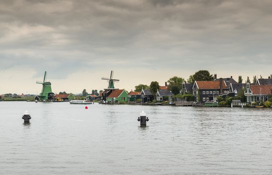 Authentic Zaandam mills on the water channel in Zaanstad village. Zaanse Schans Windmills and famous Netherlands canals, Europe.