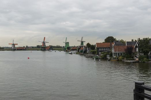 Authentic Zaandam mills on the water channel in Zaanstad village. Zaanse Schans Windmills and famous Netherlands canals, Europe.