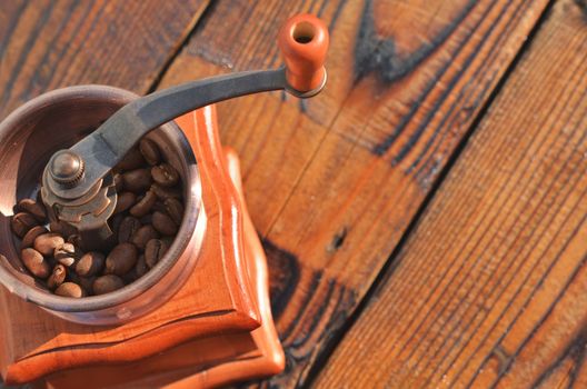 The manual horizontal coffee grinder with coffee beans on wooden boards is in the lower left corner.